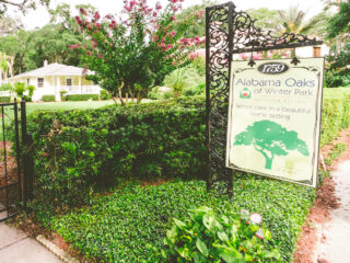 Assisted living entrance sign with a yellow residence and landscaped yard in Winter Park.