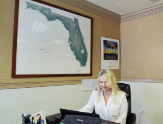 Woman working at an office desk with a laptop.