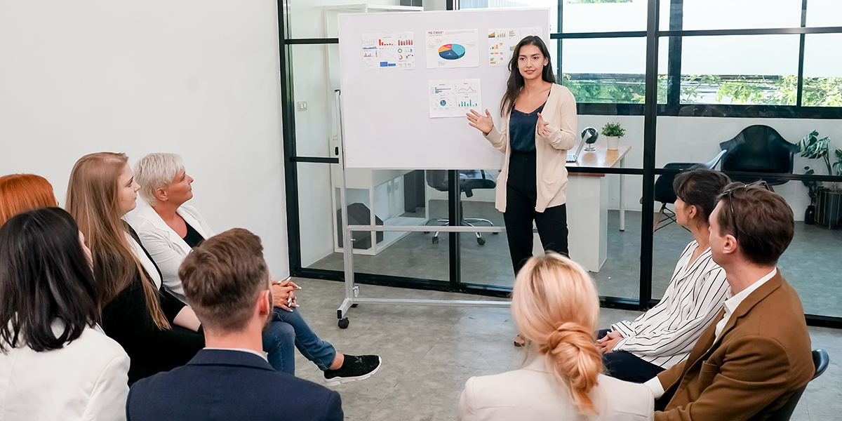 Woman presenting at business workshop to attendees