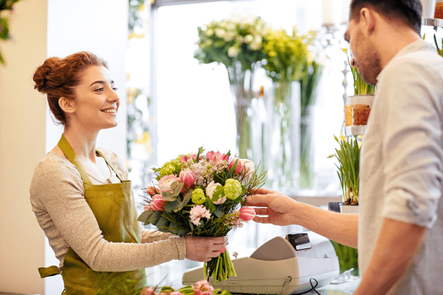 Florist handing over fresh flowers to customer