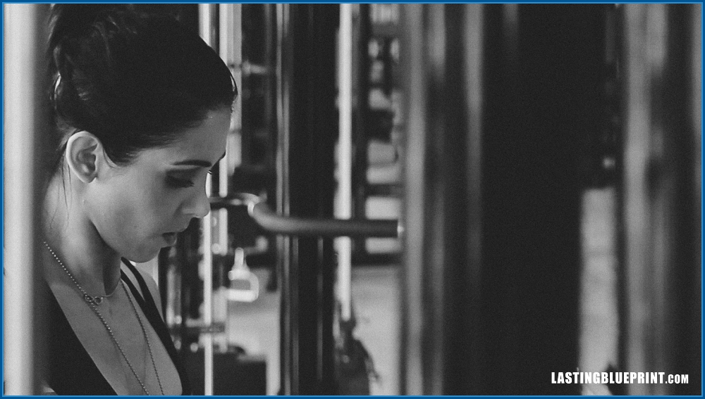 A monochrome image of bella falconi working out in a gym, focusing intently.