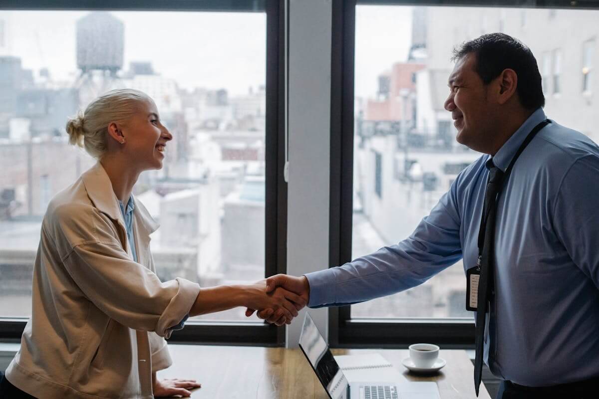 Two professionals shaking hands in office meeting