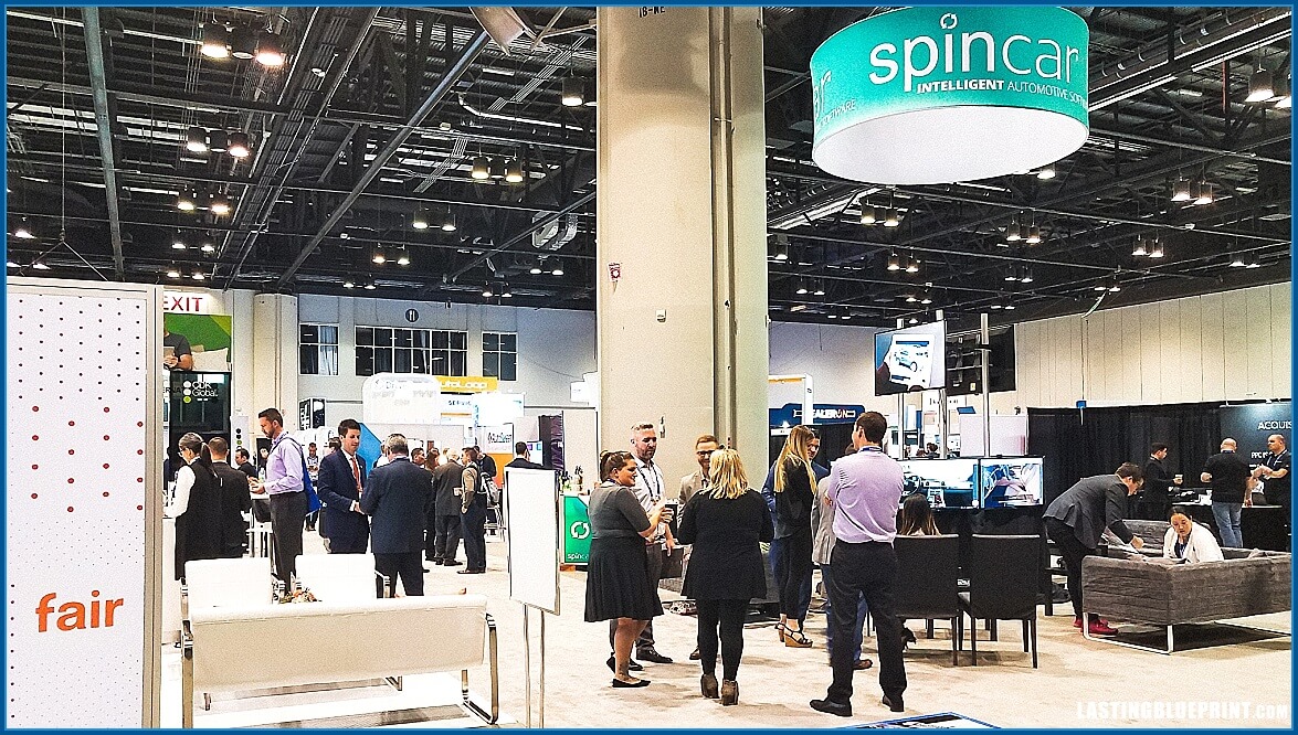 Attendees networking at a trade show booth at the orange county convention center.