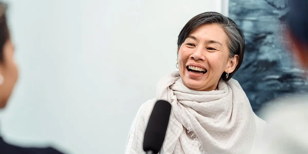 Smiling woman participating in a friendly conversation.