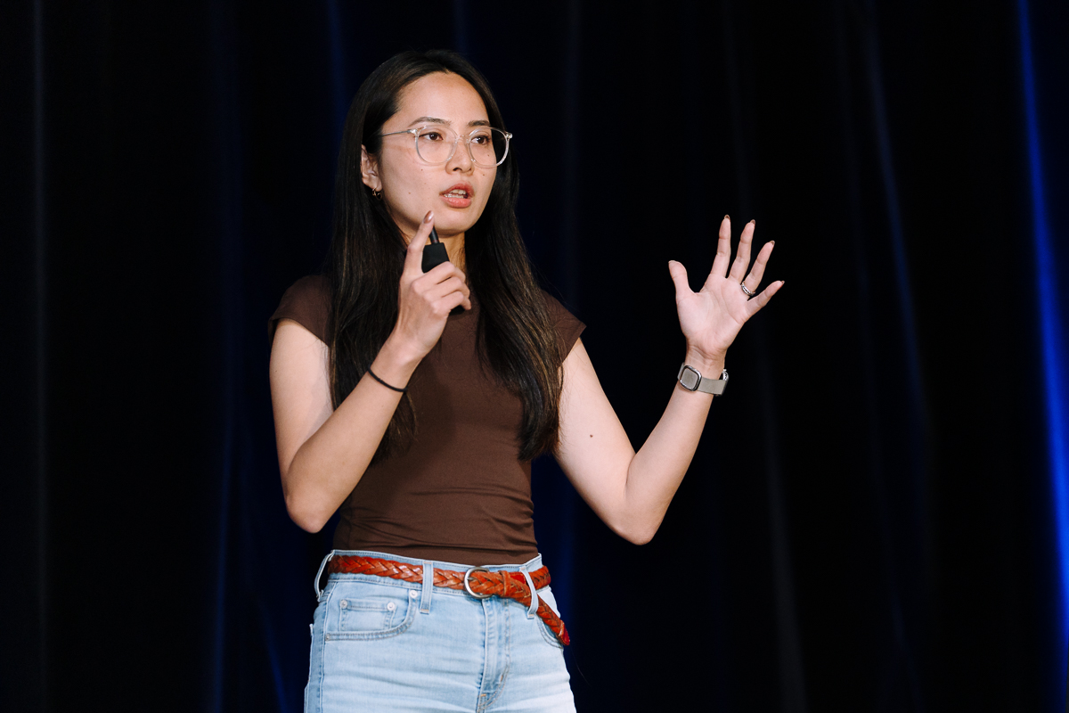 An orlando event video production company captures an asian woman with glasses speaking on stage at disney's contemporary resort convention center.