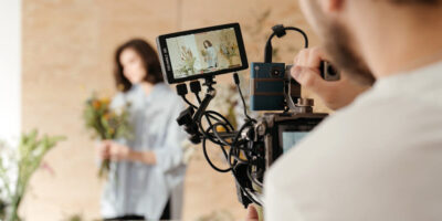 Videographer filming a woman indoors with a cinema camera