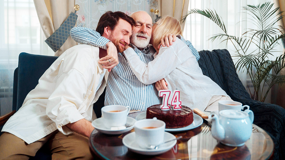 Birthday party videographer in orlando captures a family sharing a warm hug with a man.