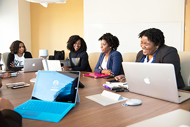 Orlando video production company captures corporate meeting with professionals in business attire gathered around a conference table with laptops.
