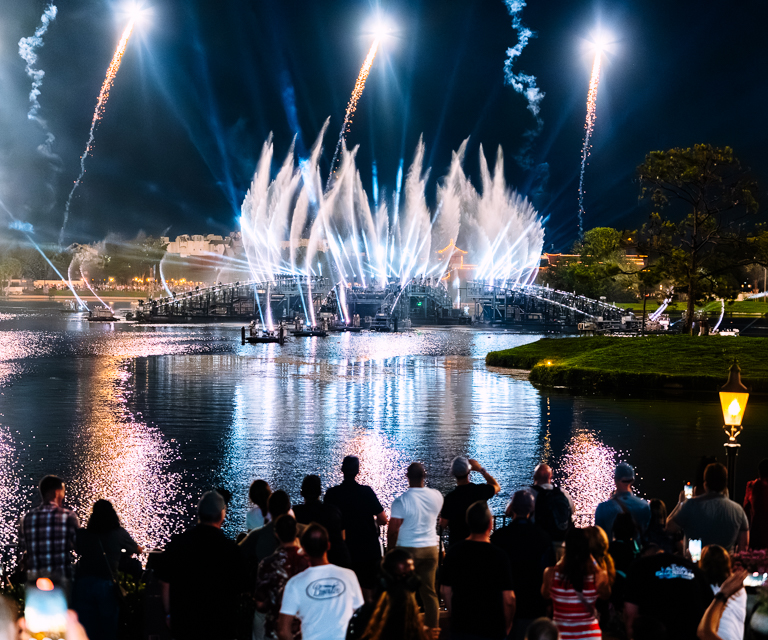 Crowd watching fireworks and water fountains during an evening reception at EPCOT.