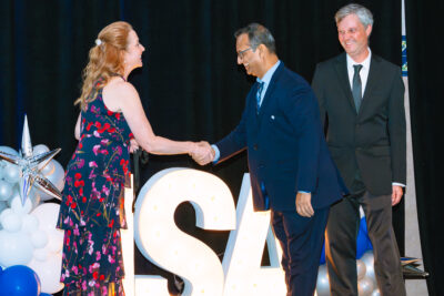 An award presentation handshake photographed during a business event at Disney’s Coronado Springs Resort.