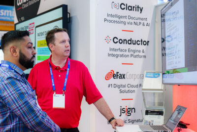Exhibitor demonstrating software at a healthcare technology trade show booth at the Orange County Convention Center.