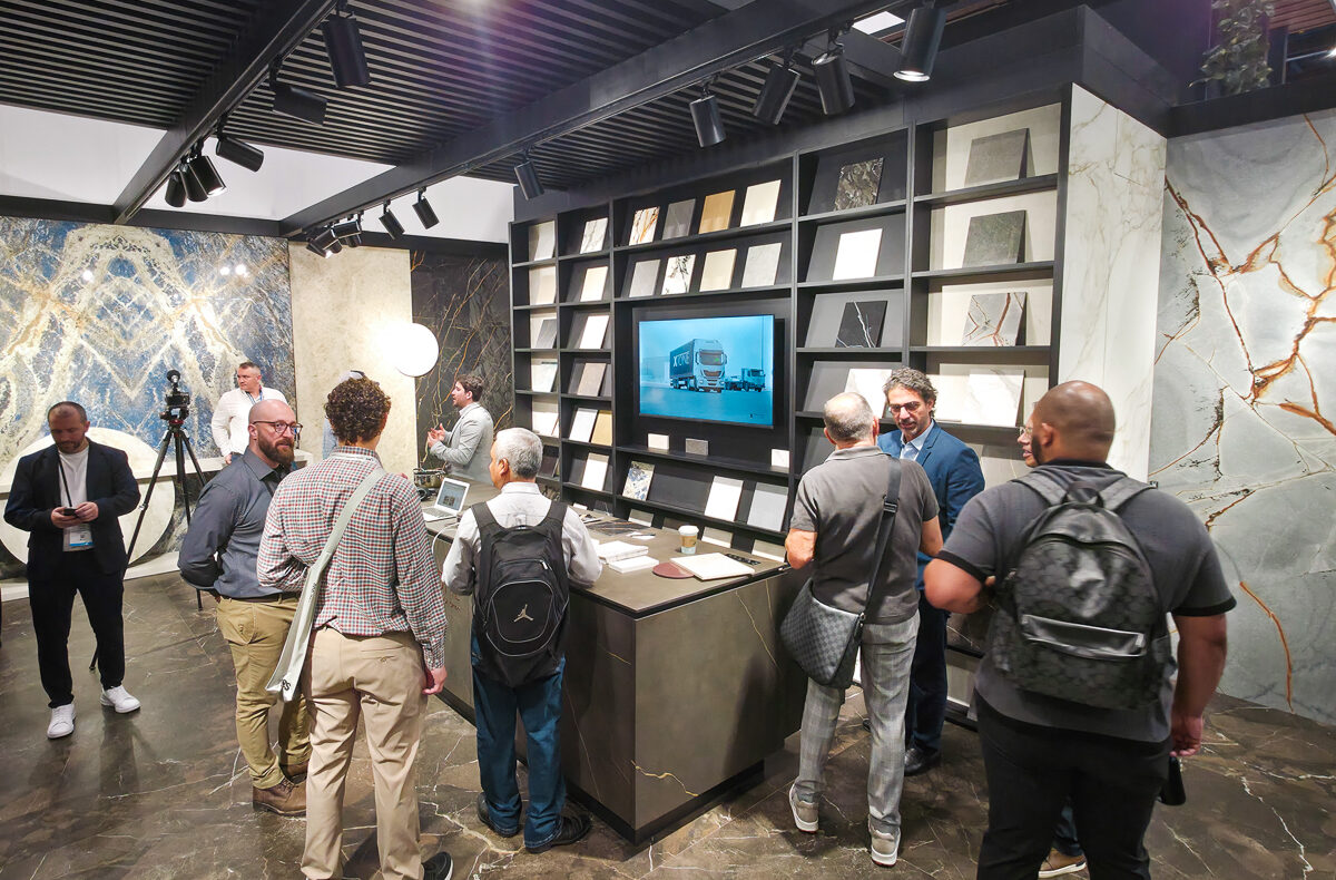 Attendees interacting with a booth display at a kitchen and bath trade show at the orange county convention center.