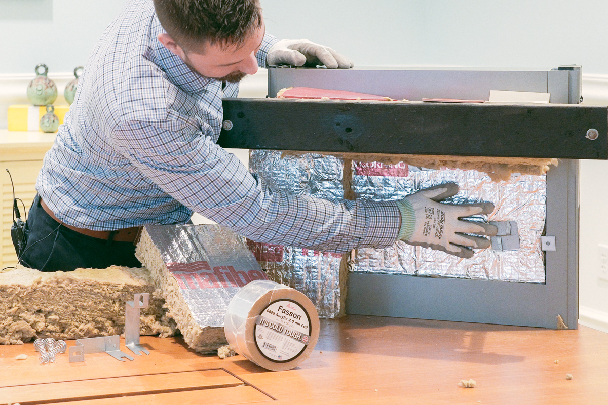 Technician installing insulation during training video production in orlando