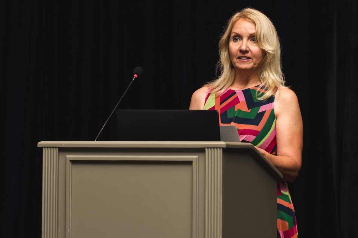 Event photography of a woman speaking at a podium during a conference awards ceremony at caribe royale orlando