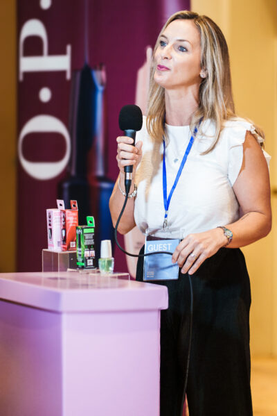 Beauty seminar attendee speaking into a handheld microphone for a testimonial interview.
