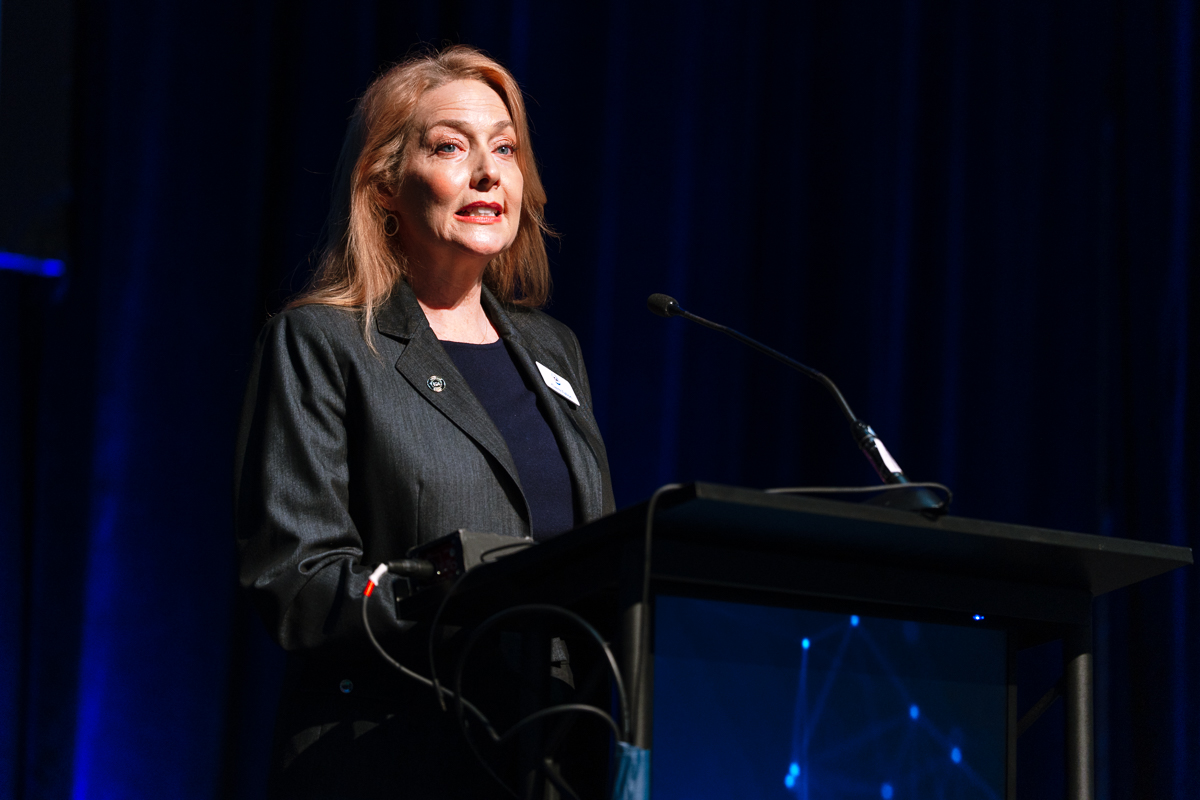 Female ceo speaking at a podium during a summit at disney’s coronado springs resort