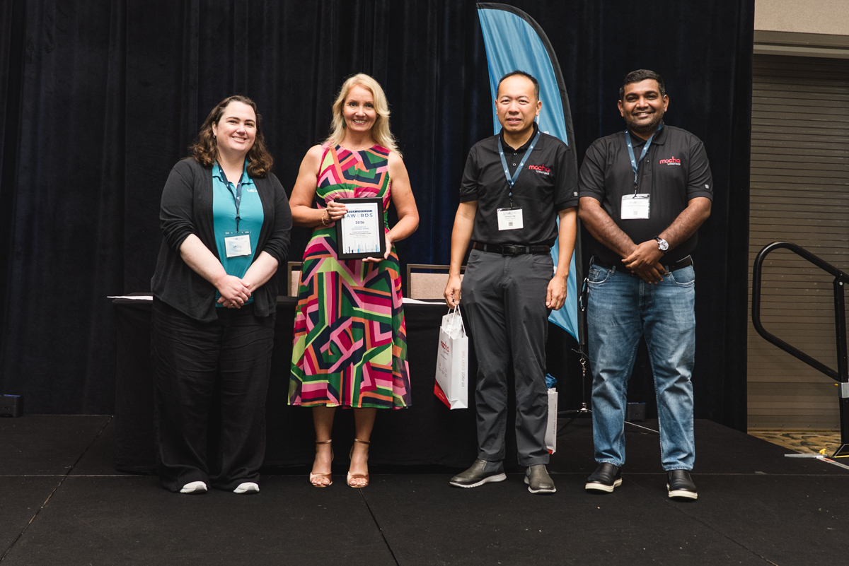 Award recipient posing with event organizers at caribe royale orlando