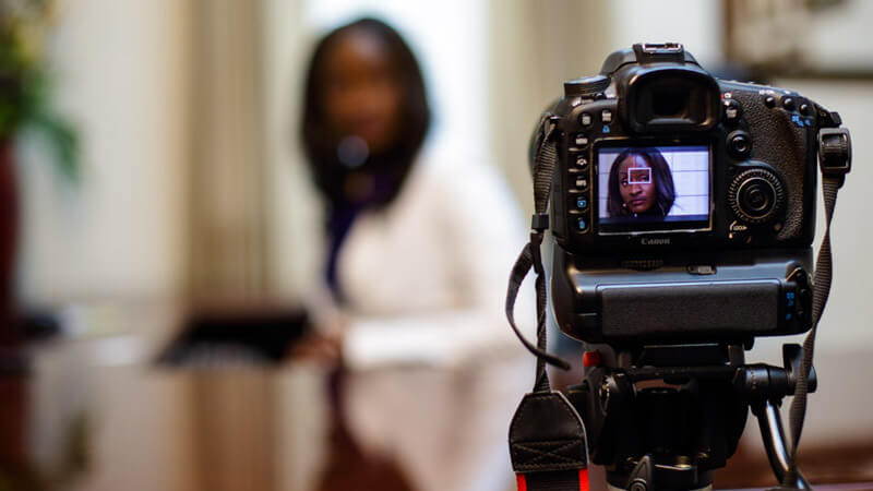 Camera filming a woman during a video interview