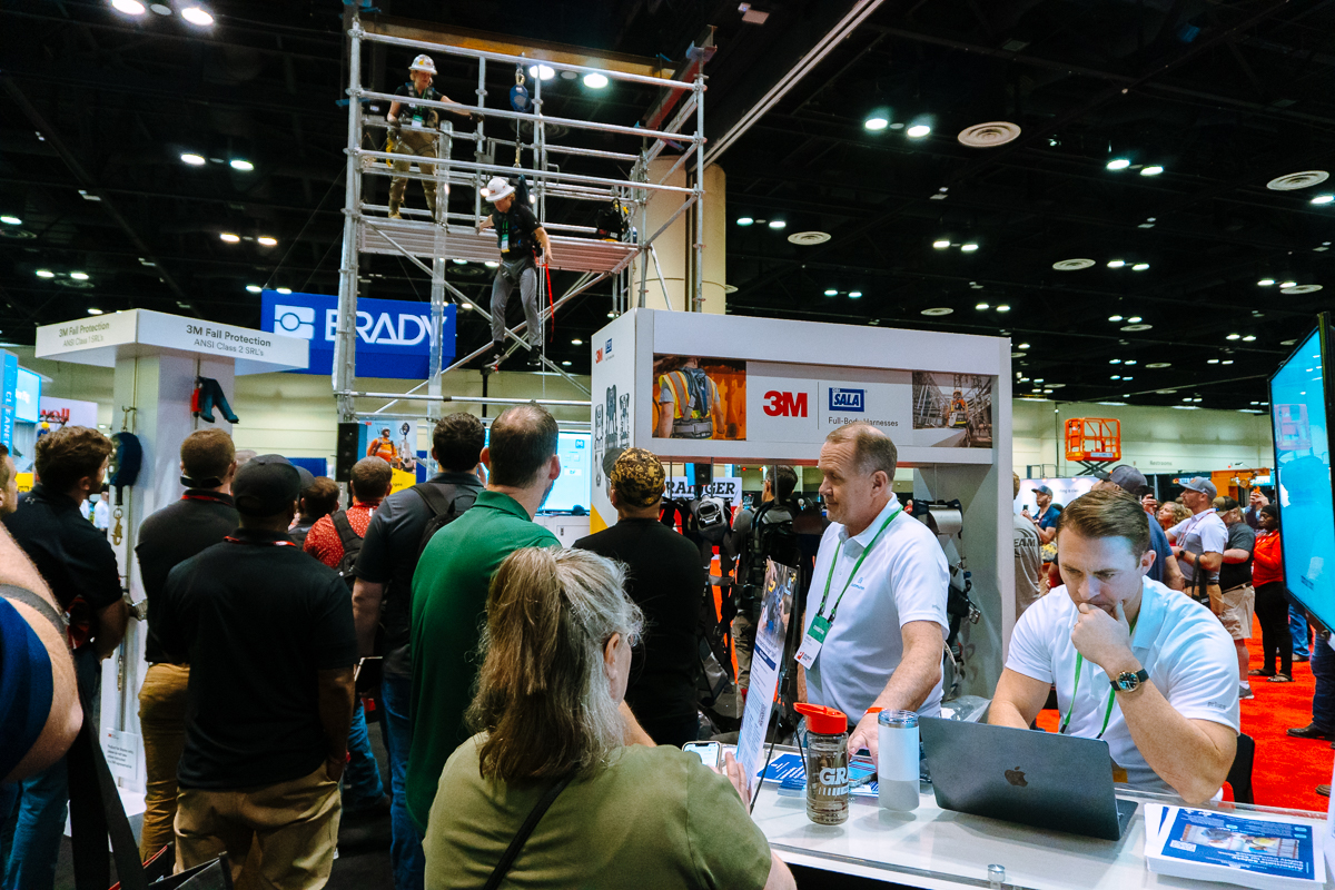 Attendees watching a live 3m fall protection safety demonstration using a scaffold at the grainger show