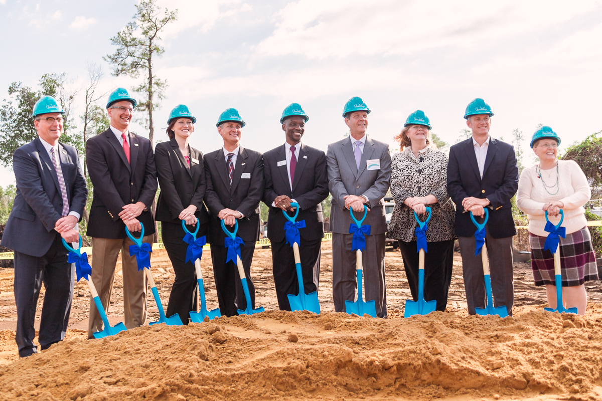 Business leaders posing with ceremonial shovels during the quest village groundbreaking ceremony in east orlando.