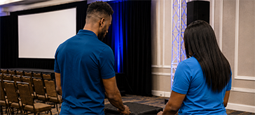 Two production staff preparing camera equipment before an orlando event