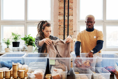 Volunteers sorting clothing and food donations for a nonprofit program.