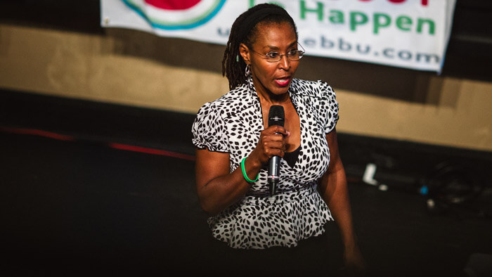 Woman speaking into a handheld microphone during an orlando event
